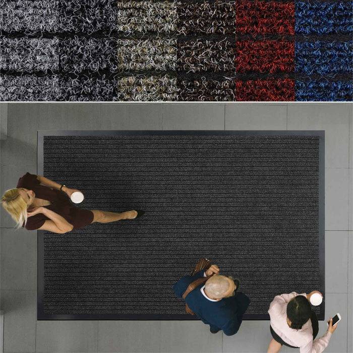 Drei Personen, von oben gesehen, die auf einer dunklen Matte laufen, in der Nähe von farbenfrohen Textildisplays in Rot, Blau und Grau auf einem Ausstellungshallenböden.