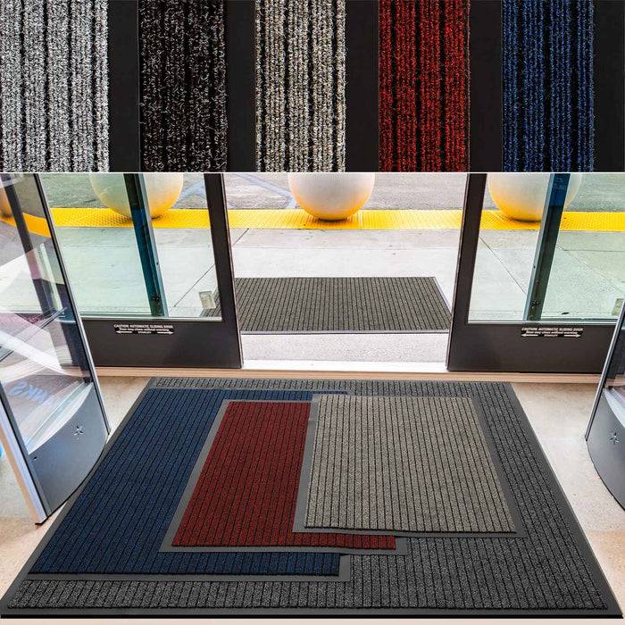 Eingang mit Fußmatte aus mehreren ineinandergreifenden farbigen Segmenten in Blau, Rot und Grau. Blick nach draußen zeigt zwei Topfpflanzen.