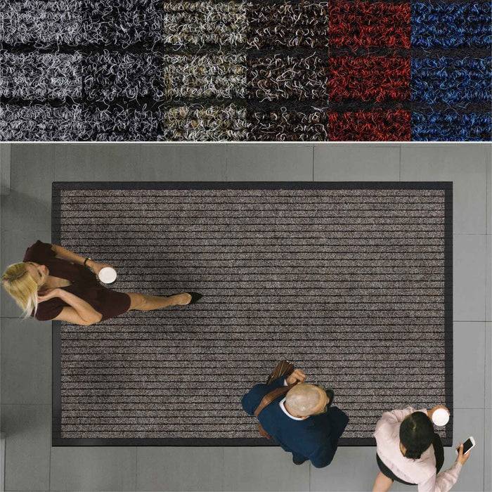 Draufsicht von drei Personen, die auf einem grauen Teppich laufen, der von verschiedenen farbigen Farbmustern umrandet ist, möglicherweise in einem Ausstellungsraum oder Geschäft.