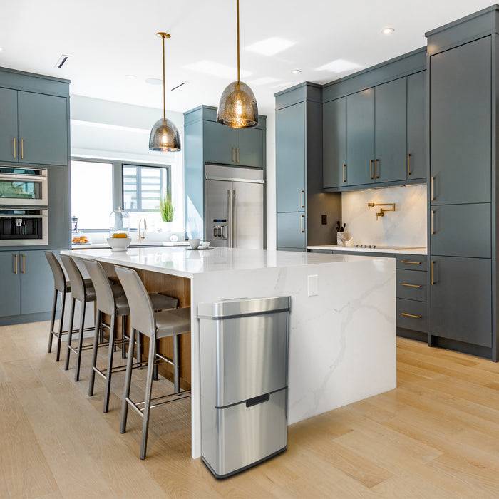 Moderne Küche mit grauen Schränken, einer Marmor-Insel und Edelstahlgeräten. Fünf Barhocker säumen die Arbeitsplatte der Insel.