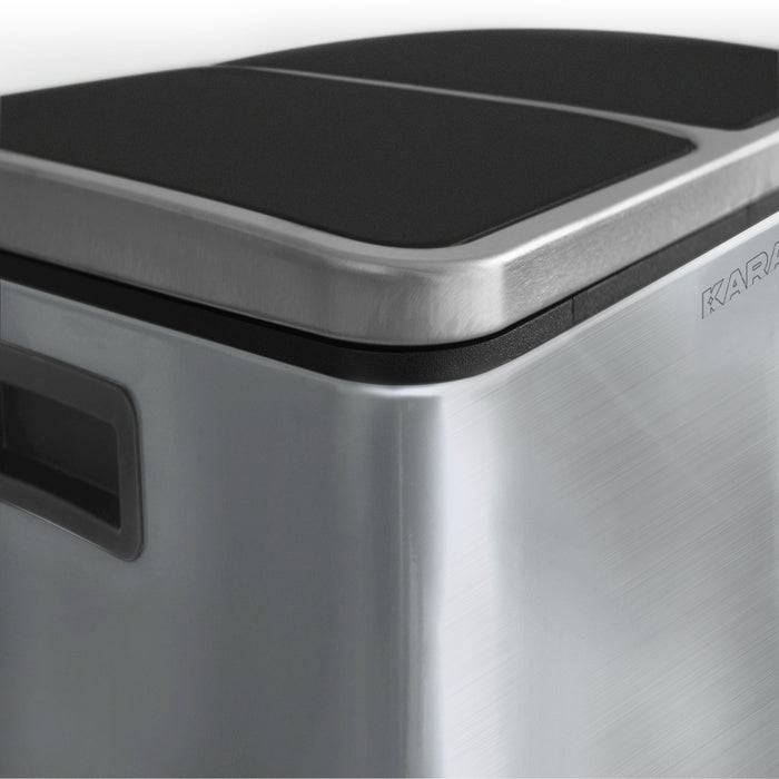 Ein rechteckiger Edelstahl-Mülleimer mit schwarzem Deckel, gestaltet, um elegant und modern zu wirken, möglicherweise für eine Küchenumgebung.