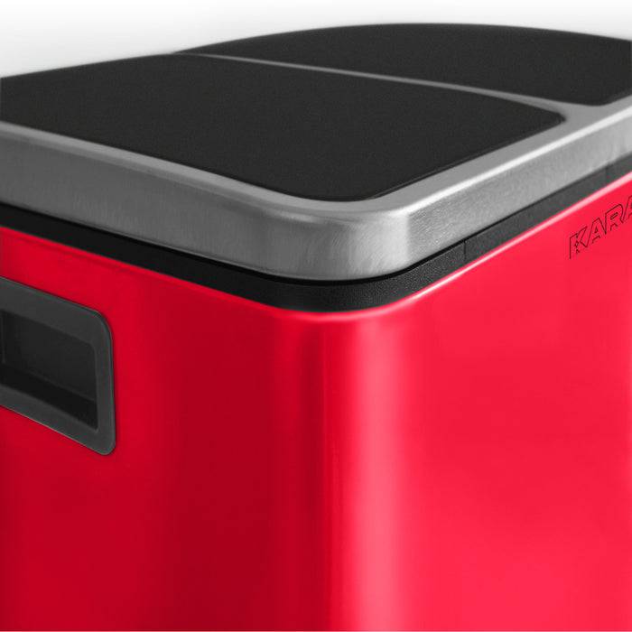 Ein roter rechteckiger Mülleimer mit einem schwarzen und silbernen Deckel, mit einem Seitengriff, von oben in einem Winkel gezeigt.