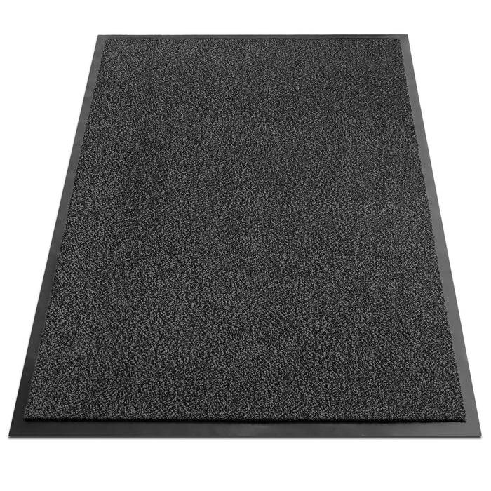 Eine strukturierte schwarze Fußmatte mit Gummieinfassung, die zum Entfernen von Schmutz von Schuhen entwickelt wurde, von oben aufgenommen.