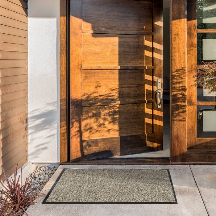 Offene Holz-Eingangstür mit modernem Design, flankiert von einer kleineren Flügeltür mit Glaseinsätzen. Sonnenlicht erzeugt Muster auf den Türen.