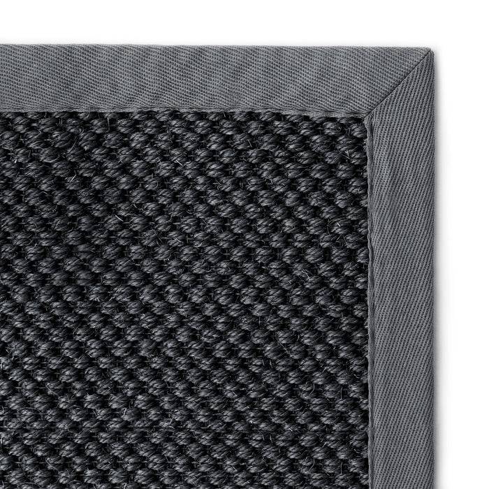 Nahaufnahme einer dunkelgrauen gewebten Stoffstruktur mit hellgrauem Rand, die das raue und detaillierte Muster des Materials hervorhebt.