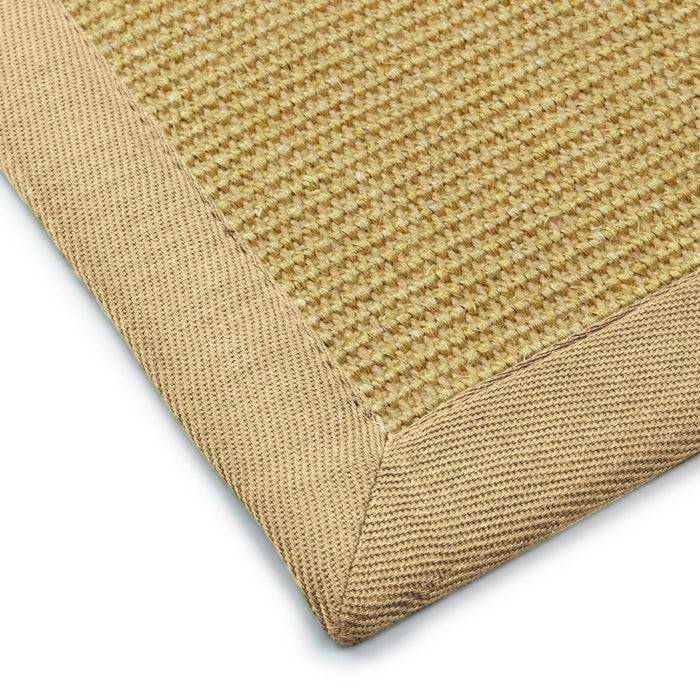 Ecke eines gewebten beigefarbenen Teppichs mit strukturiertem Rand, das Material und die Handwerkskunst zeigend.