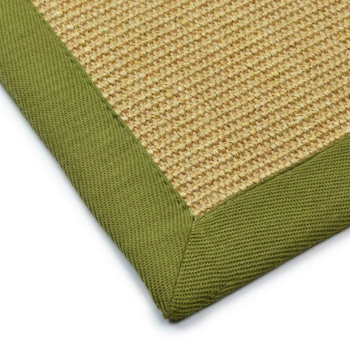 Nahaufnahme eines gewebten beigefarbenen Teppichs mit grünem Stoffrand, zeigt Textur und Nähdetails.