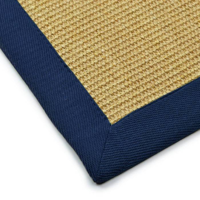 Ecke eines gewebten beigen Teppichs mit dunkelblauen Rand, der Textur und Farbkontrast zeigt.
