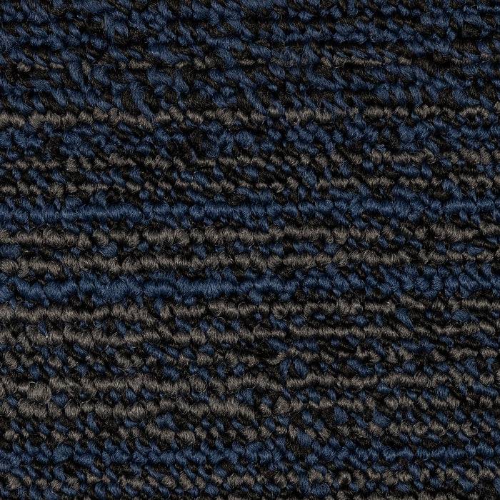 Eine Nahaufnahme eines dunklen, strukturierten Teppichstoffs mit einer Mischung aus schwarzen und dunkelblauuen Fasern, die ein raues, geschlungenes Muster aufweist.