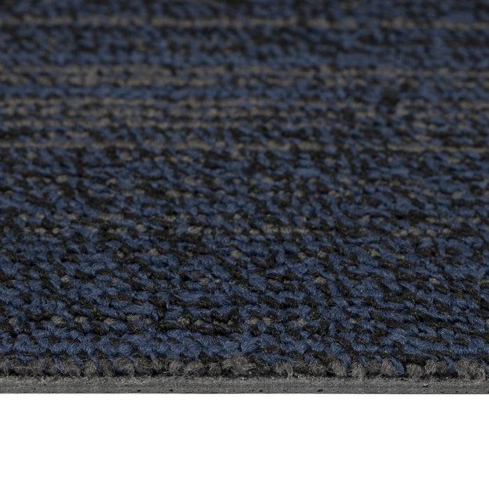 Nahaufnahme einer blau und grau gemusterten Teppichfliese, die ihre Textur und Dicke zeigt.