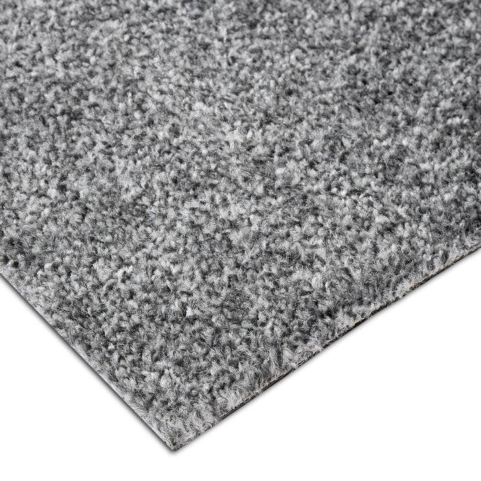 Nahaufnahme einer grauen strukturierten Teppichkante mit weichem, kurzem Flor.