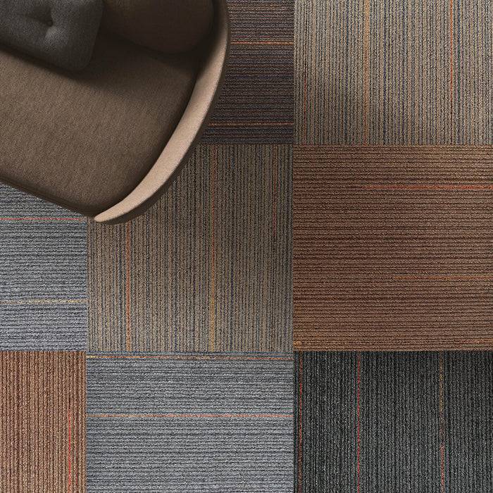 Luftaufnahme eines Stuhls auf einem karierten Teppich, die verschiedene strukturierte und farbige quadratische Muster zeigt, einschließlich Schattierungen von Braun, Grau und Schwarz.