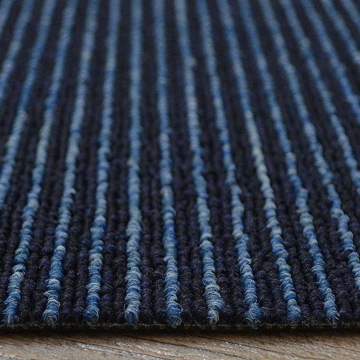 Eine Nahaufnahme eines blau und schwarz gestreiften Teppichs, der die strukturierte Oberfläche und das Muster zeigt.