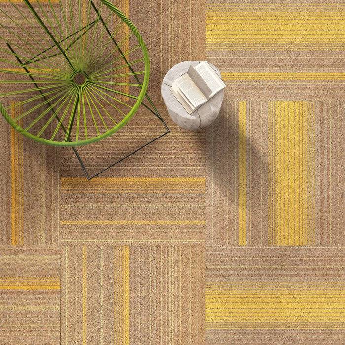 Luftaufnahme eines grünen Drahtsstuhls und eines kleinen Tisches mit Büchern auf einem gemusterten Teppich mit gelben und braunen Quadraten, die ein geometrisches Design schaffen.