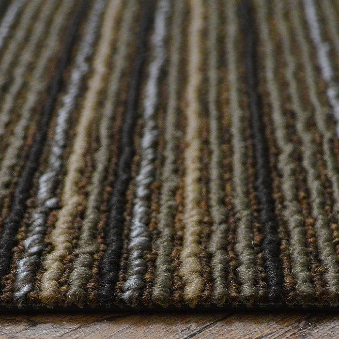 Nahaufnahme eines dunkelbraun und beige gestreiften strukturierten Teppichs auf einem Holzboden, der sein gewebtes Detail und Muster zeigt.