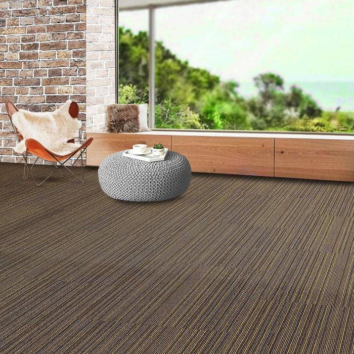 Ein modernes Zimmer mit einer Ziegelmauer als Akzentwand, großem Fenster mit Blick auf Grünflächen und braunem strukturiertem Bodenbelag. Ein Stuhl, ein Kissen und eine Tasse auf einem Tablett sind sichtbar.