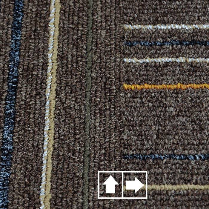 „Eine Nahaufnahme eines strukturierten braunen Teppichs mit parallelen Linien in verschiedenen Farben. Zwei Pfeile, einer zeigt nach oben und der andere nach rechts, befinden sich am unteren Rand.