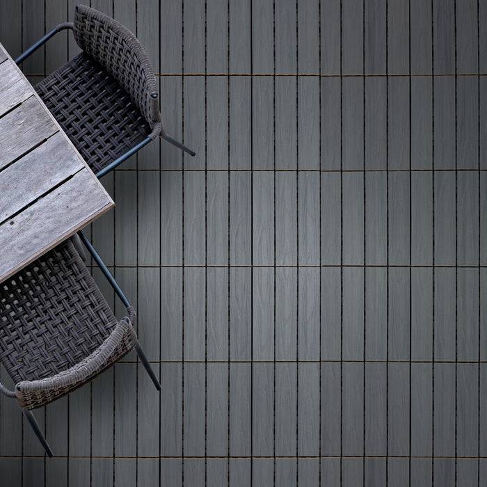 Zwei schwarze Korbstühle und ein Holztisch auf einem grauflieseigen Boden, von oben betrachtet.