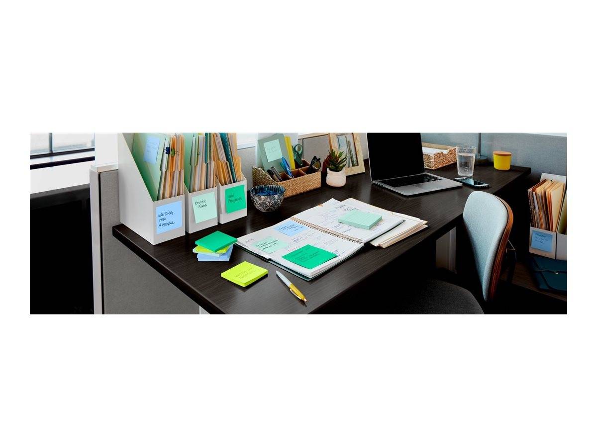 Organisierter Bürotisch mit offener Agenda, Haftnotizen, Aktenmappen, Laptop und Stuhl in einem ordentlichen Arbeitsbereich.