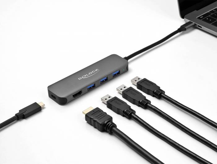 Ein USB-C-Hub, der mit einem Laptop verbunden ist und mehrere USB-Anschlüsse zeigt, mit mehreren angestöpselten Kabeln auf weißem Hintergrund.
