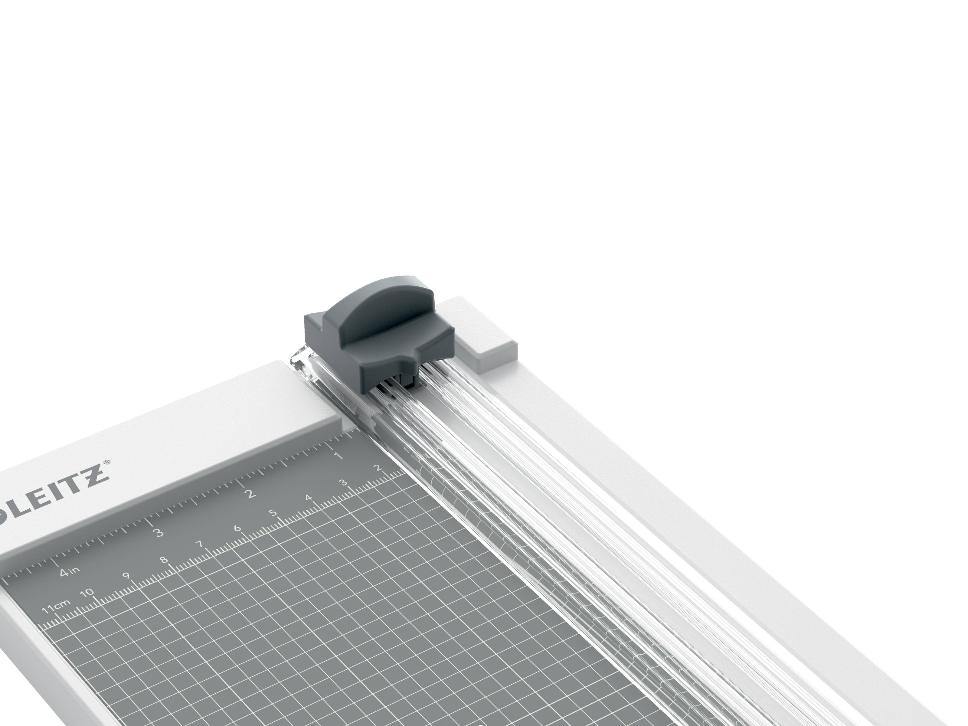 Foto eines LEITZ-Papierschneiders mit grauer Schneidematte, Linealgitter und verschiebbarer Klingenführung auf schwarzem Hintergrund.