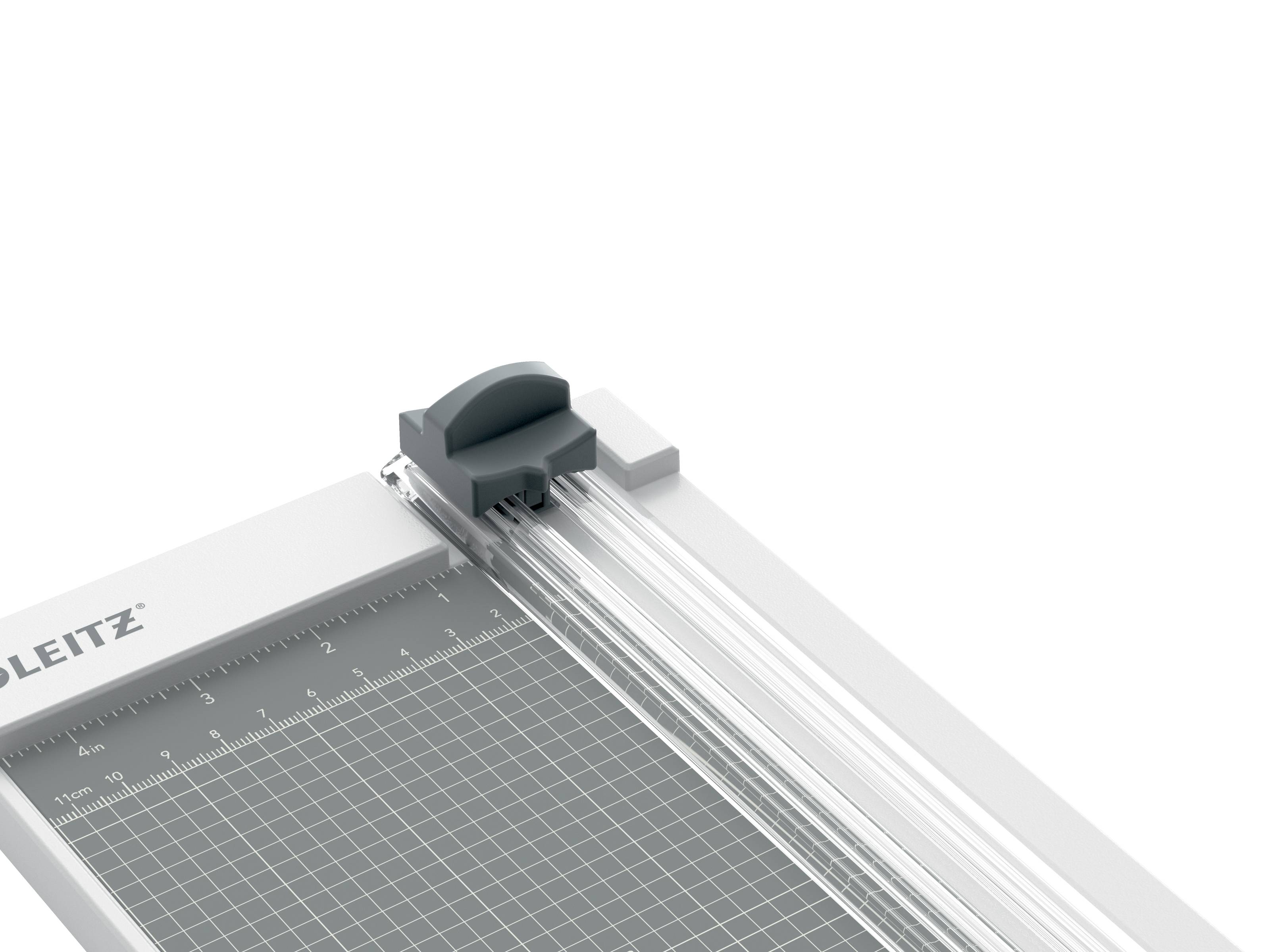 Nahaufnahme eines Papierschneiders oder Cutters mit einem grauen Messgitter, Linealmessungen und einem Schiebegriffwerk auf weißem Hintergrund.