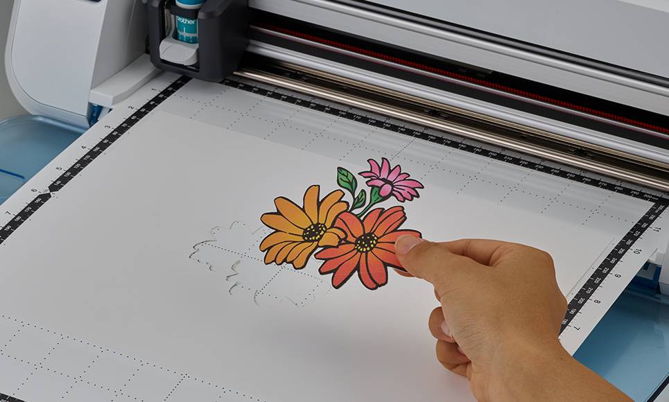 Eine Hand zeigt auf ein buntes Blumendesign, das auf einem Großformatdrucker gedruckt wird.