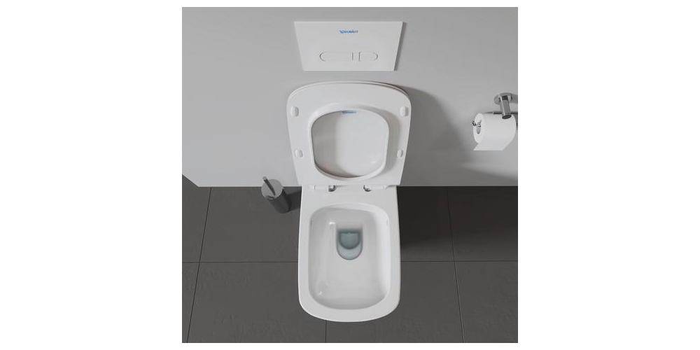 Draufsicht auf eine weiße Toilette in einer Toilettenkabine mit grauen Bodenfliesen und einem Toilettenpapierhalter an der Wand.