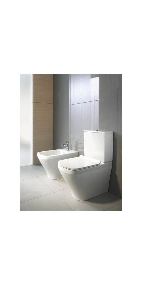 Modernes Badezimmer mit weißer Toilette und passendem Bidet neben einer gefliesten Wand und Holzakzentpaneel.