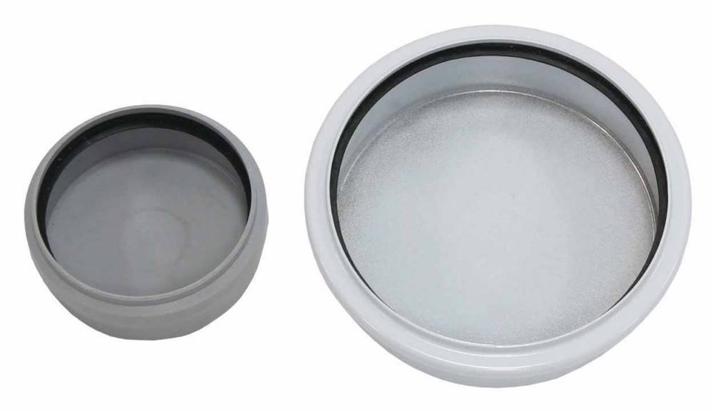 Zwei runde Metalldeckel oder Behälter nebeneinander gezeigt, einer kleinerer dunkelgrau und einer größerer silber, beide von oben auf weißem Hintergrund betrachtet.
