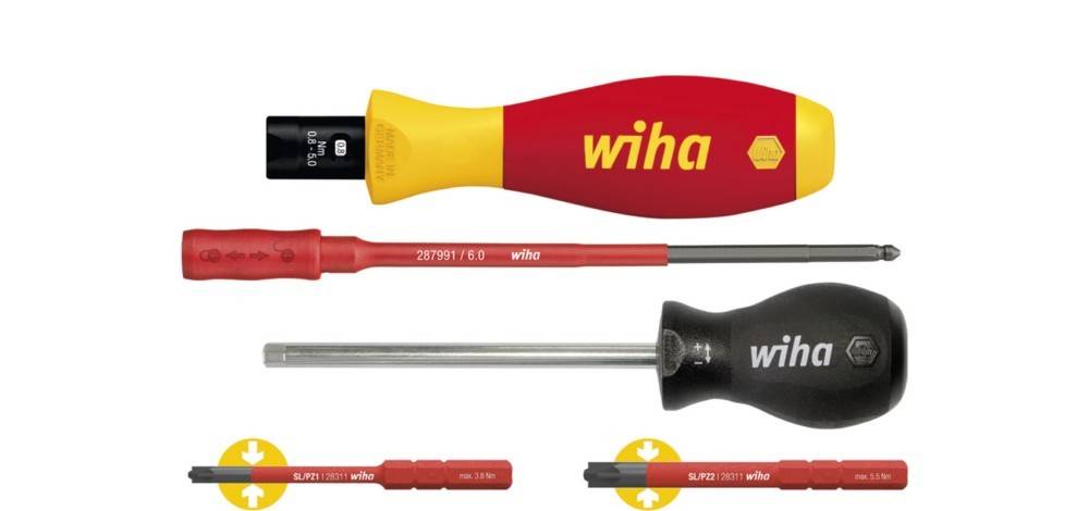 Satz von Wiha-Schraubendrehern und austauschbaren Bits: rot-gelb isolierter Griff, roter schlanker Drehereinsatz, Drehereinsatz mit schwarzem Griff und zwei Bithalter mit Richtungspfeilen.