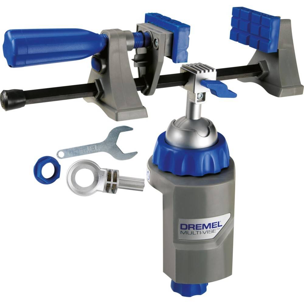 Eine Dremel Multi-Vise-Spannvorrichtung mit blauen und grauen Backen, drehbarer Basis und im Lieferumfang enthaltenen Schraubenschlüssel und Adapterstücken, dargestellt auf weißem Hintergrund.