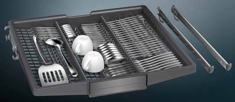 Ein Küchenschubladenorganizer mit ordentlich angeordnetem Silberbesteck, darunter Gabeln, Löffel, Messer und zwei weiße Tassen.