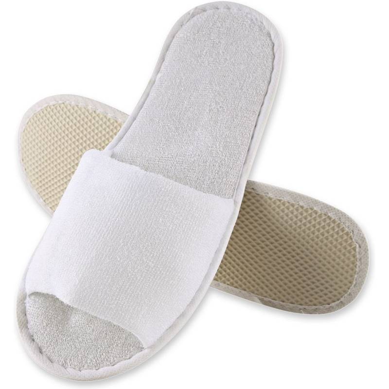 Zwei weiße Frottee-Hausschuhe, einer auf dem anderen liegend. Die Oberseite zeigt das offene Zehendesign, während die Unterseite die strukturierte Sohle präsentiert.