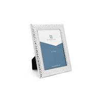 Ein silberner Bilderrahmen steht schräg, der eine blaue und weiße Platzhaltertafel mit '8x10' und 'Everyday' zeigt.