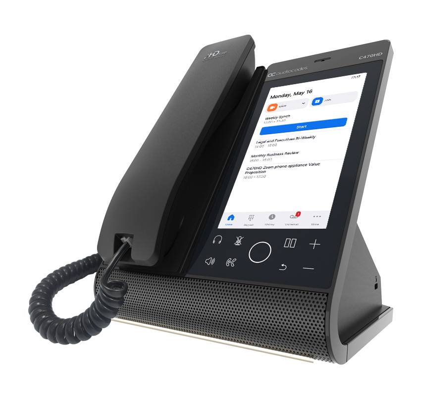 Schwarzes Schreibtisch-Hoteltelefon mit Touchscreen, Hörer, Tastenfeld-Symbolen und Spiralkabel, dargestellt auf weißem Hintergrund.