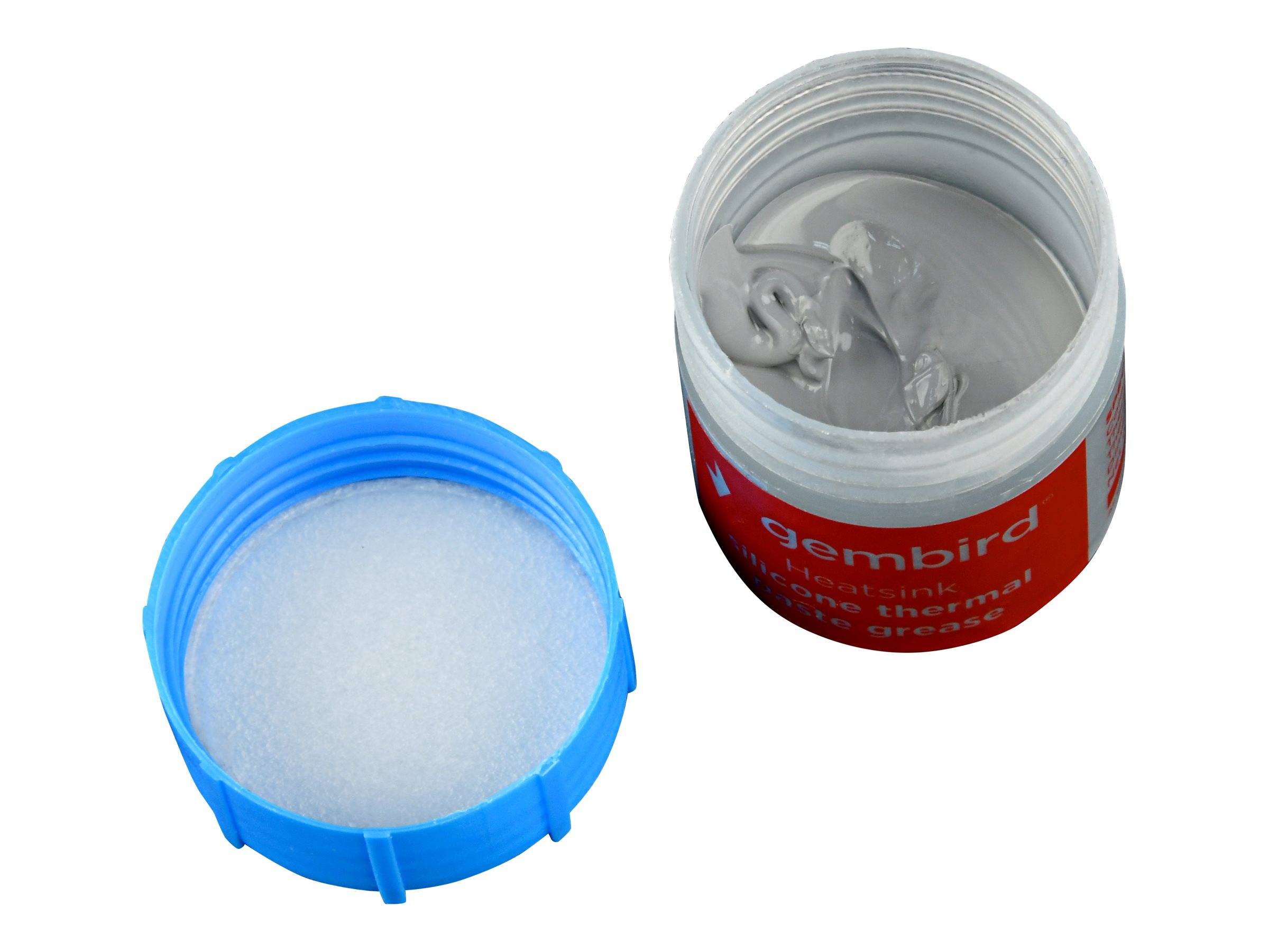 Offenes Glas mit grauer Spachtelmasse oder Paste mit abgenommenem Deckel neben einer blauen Kunststoffkappe gefüllt mit weißem Granulat.