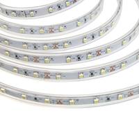 Aufgewickelte Rolle von weißen LED-Streifenleuchten mit sichtbaren Glühbirnen und Verdrahtung auf weißem Hintergrund.