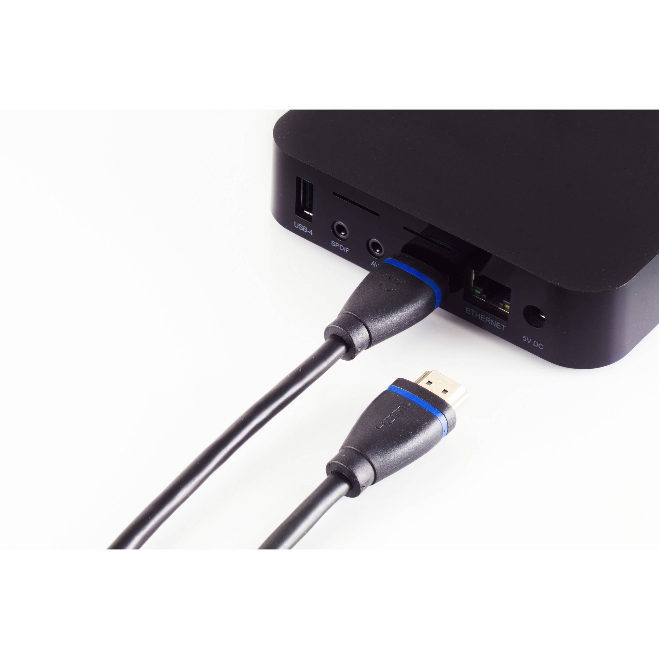 Nahaufnahme einer schwarzen Media-Box mit einem HDMI-Kabel, das in die hintere Buchse eingesteckt ist, mit sichtbaren USB-, Audio- und Netzwerkverbindungen.