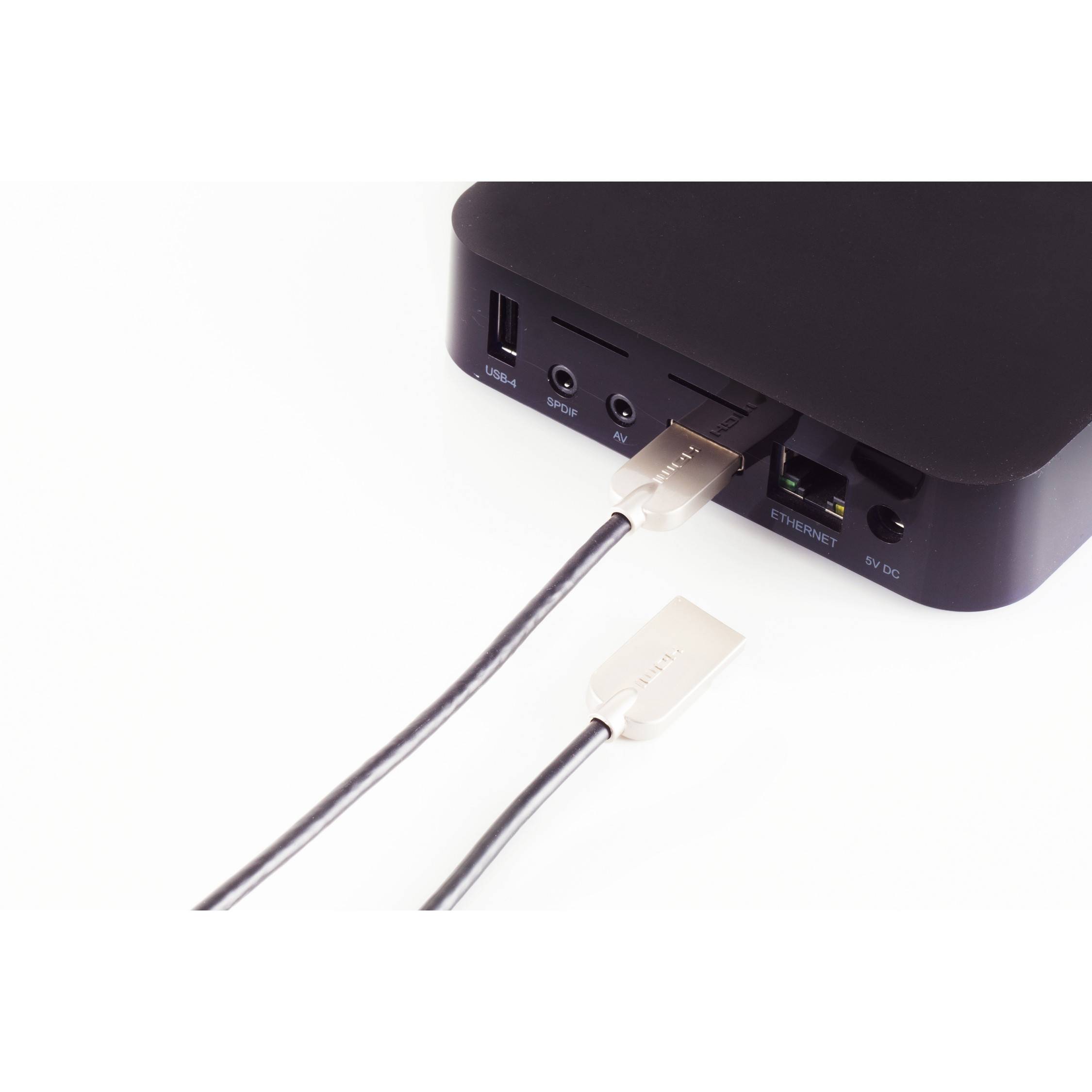 Nahaufnahme einer schwarzen Media-Box oder eines Computer-Docks mit einem Ethernet-Kabel, das in den Netzwerkport gesteckt ist, und einem anderen Kabel in der Nähe.