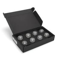 Offene schwarze Geschenkbox mit sieben kleinen durchsichtigen runden Behältern oder Leuchten auf einer schwarzen Einlage.