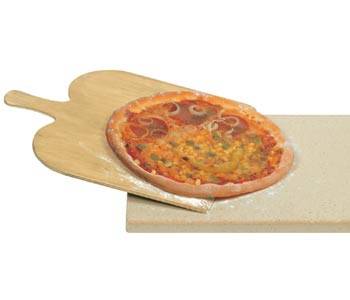 Pizza auf einer Holzschaufel wird in einen heißen Ofen auf einer Stein- oder Metallbackfläche geschoben.
