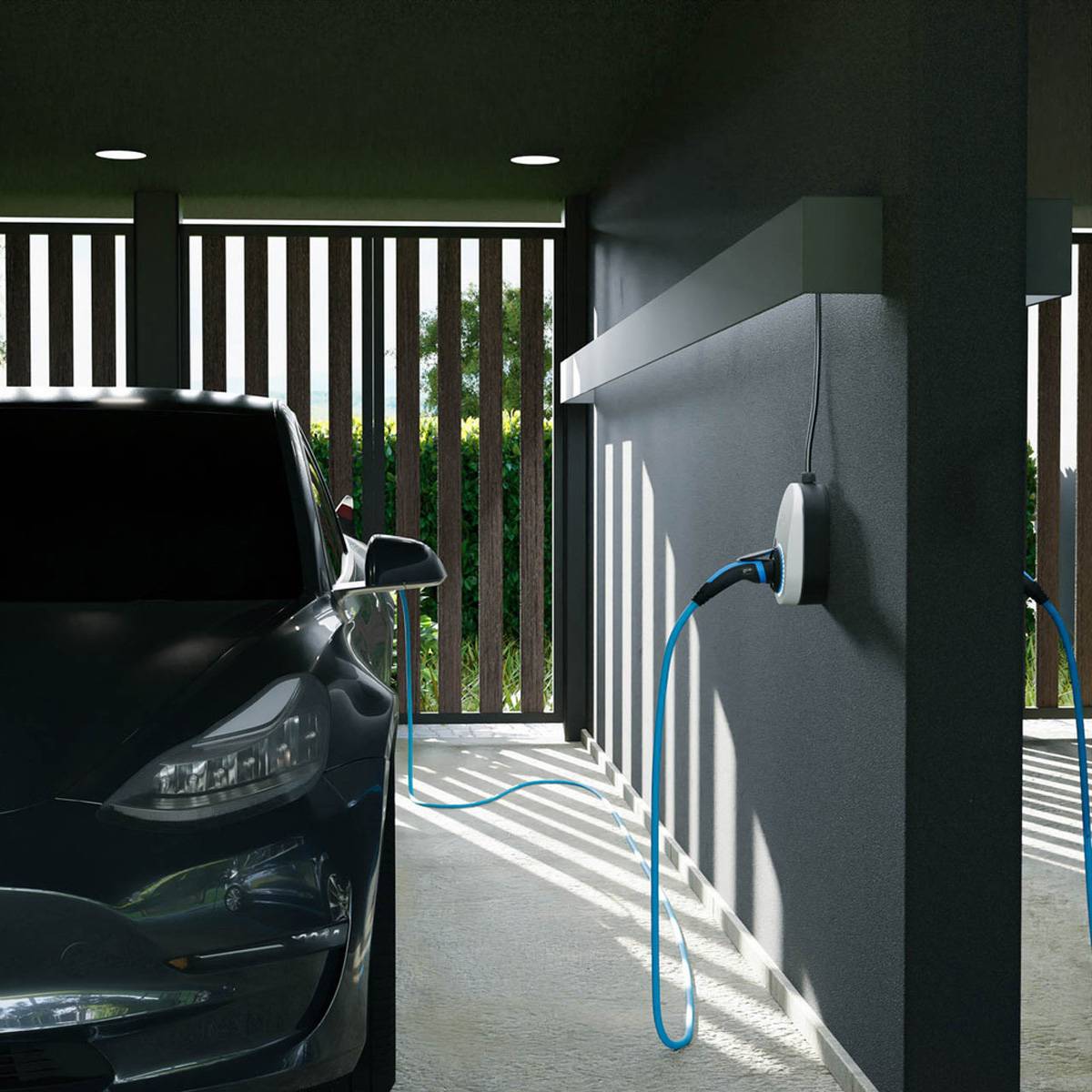Ein Elektroauto wird in einer überdachten Einfahrt aufgeladen, mit einem blauen Ladekabel, das in eine Steckdose an der Wand neben einem geparkten schwarzen Auto gesteckt ist.