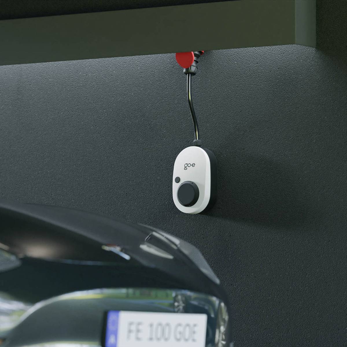 Weißer GOE-Sensor oder Fernbedienung, an einem Autohimmel in der Nähe der Windschutzscheibe angebracht, mit einem kleinen Display, das „FE 100 GOE