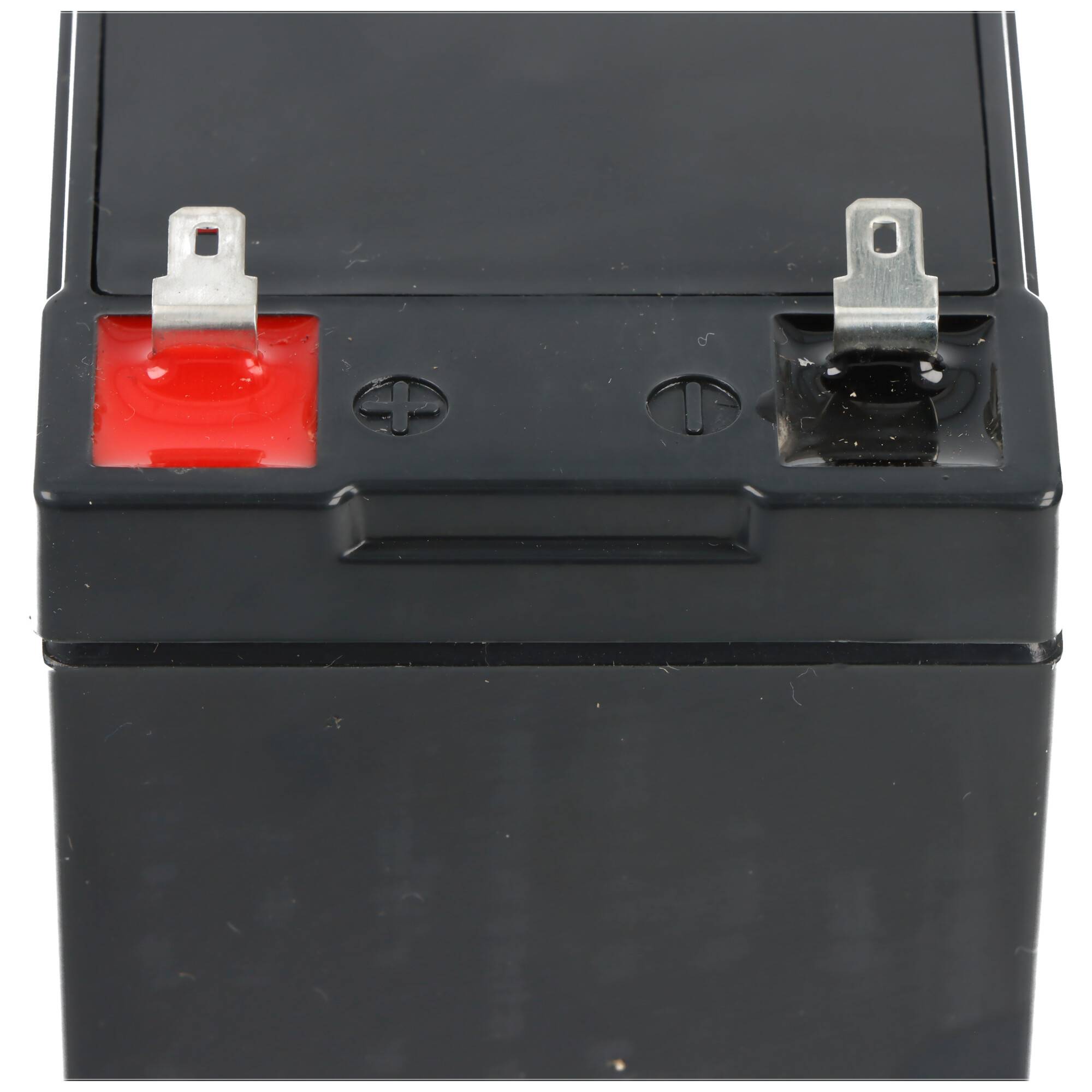 Schwarze Batterie mit rotem Pluspol und schwarzem Minuspol, gekennzeichnet mit Plus- und Minuszeichen