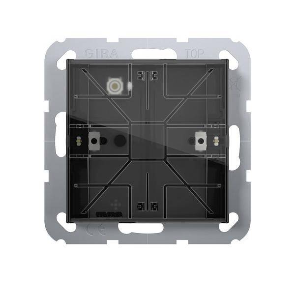 Elektrischer Schalter mit einer schwarzen Oberfläche mit quadratischen Mustern, einem kleinen Lichtindikator in der Ecke und einem silbernen Befestigungsrahmen.