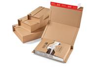 Offene Pappschachtel mit Stufeneinsätzen und einer Produktverpackung im Inneren, neben einem Stapel gefalteter Schachteleinsätze auf weißem Hintergrund dargestellt.