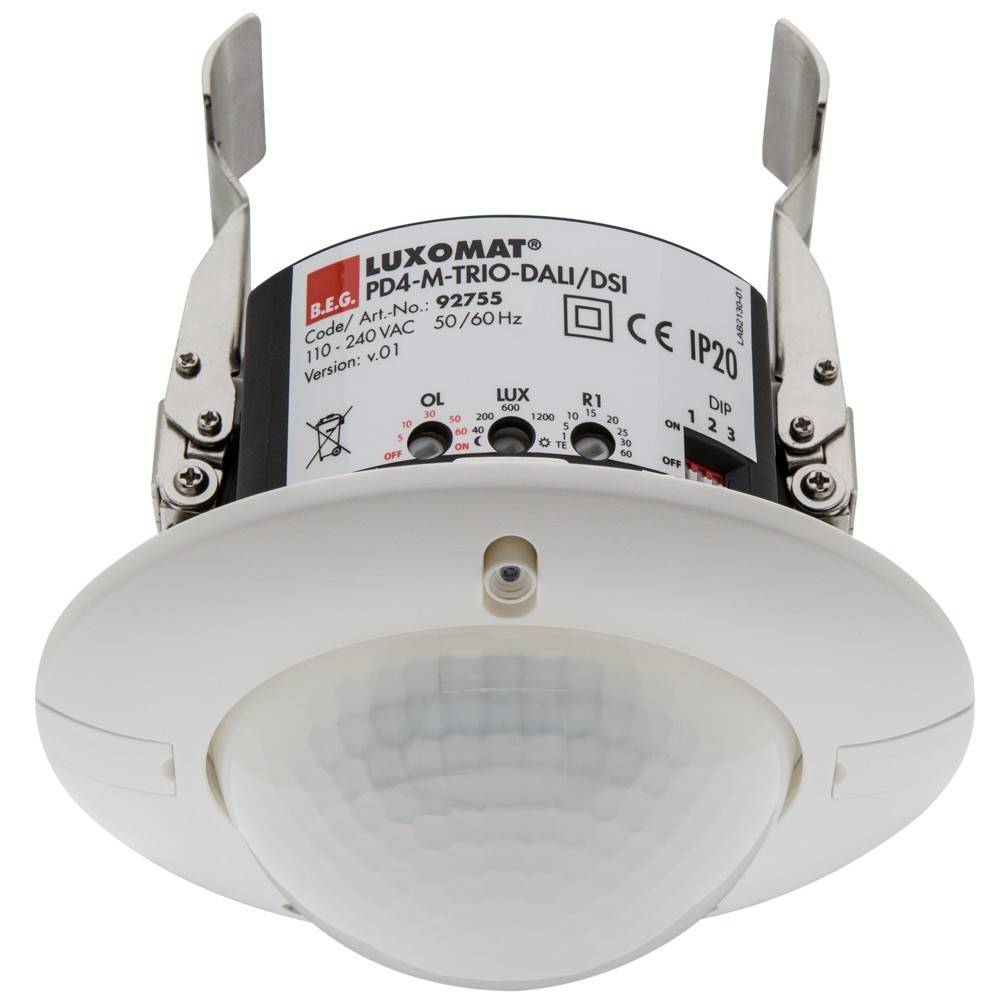 Ein weiß­er, an der Decke mon­tier­ter Be­we­gungs­mel­der mit Kup­pel­form und Ein­stel­lungs­pa­neel oben, mit Ein­stel­lun­gen für Licht­emp­find­lich­keit und Reich­wei­te.