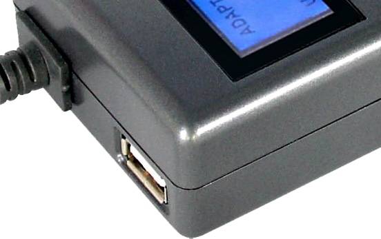 Nahaufnahme eines schwarzen elektronischen Geräts mit blauem LCD-Bildschirm, eingestecktem Stromkabel und einem USB-Anschluss an der Seite.