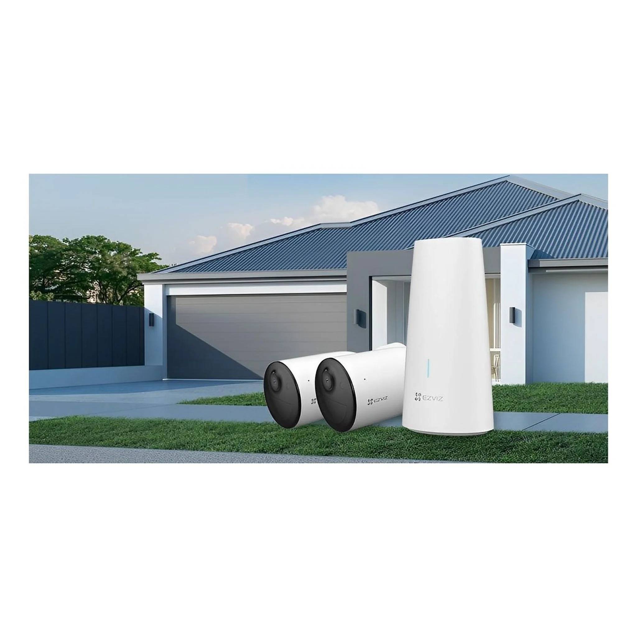 Drei Außensicherheitskameras und eine hohe weiße Basiseinheit werden auf einem Rasen vor einem modernen Haus und einer Garage ausgestellt.